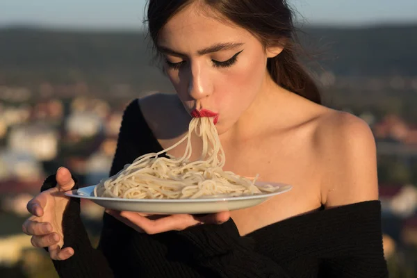 Rezept der traditionellen italienischen Küche. Nudelrezept in den Händen einer Frau, die Makkaroni isst — Stockfoto