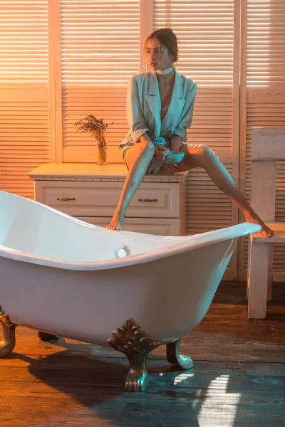 Mujer sentada en el cajón en el baño. Mujer de moda con chaqueta en el baño. Chica de la belleza comer comida de cuenco. Dieta para la salud y la salud —  Fotos de Stock