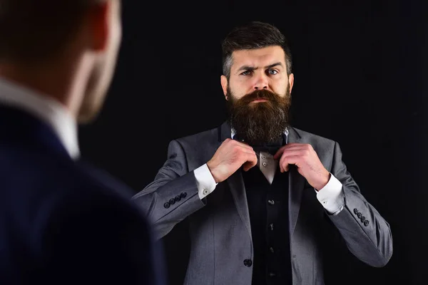 Reunión de empresarios de renombre, fondo negro. Hombre con barba en cara seria, corbata de lazo antes de reunirse. Concepto de reunión de negocios. Empresarios, socios de negocios en ropa formal, desenfocados . —  Fotos de Stock