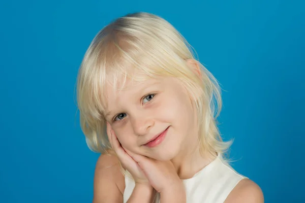 Primer plano retrato de una niña divertida. niño en estudio azul . —  Fotos de Stock