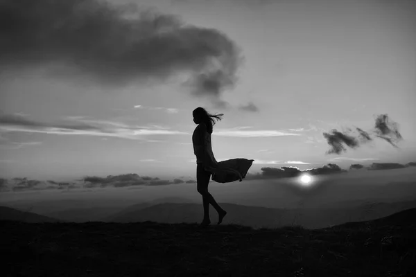 Женщина на закате или восходе солнца в горах — стоковое фото
