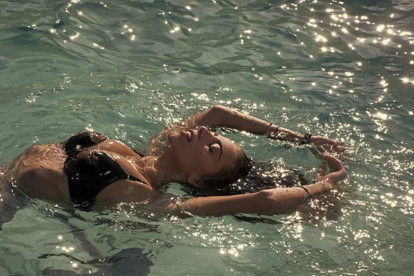 La belleza de la mujer es hidratada. Mujer sexy en el mar Caribe en Bahamas. Relájese en la piscina spa, refresco y cuidado de la piel. Vacaciones de verano y viajes al océano. Maldivas o agua de playa en Miami . — Foto de Stock