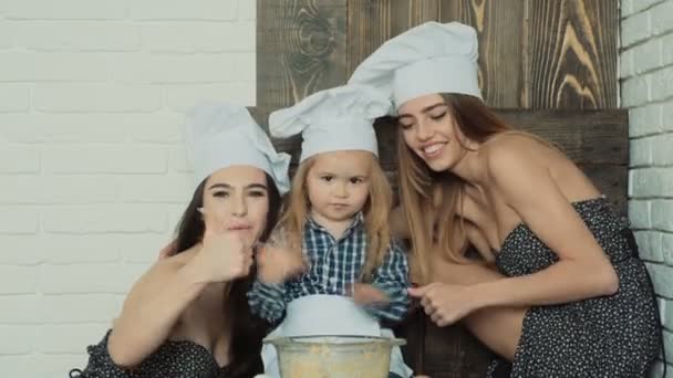 Lesbisch koppel koken met hun geadopteerde kind. Zusjes koken met hun jongere broer. — Stockvideo