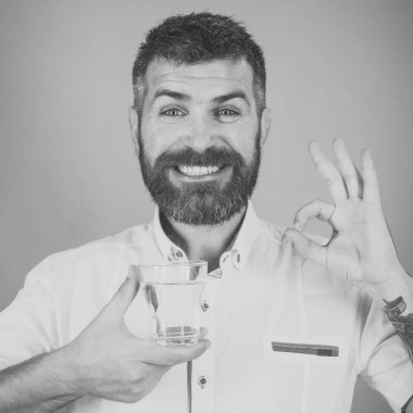 Uzun sakallı adam tutun su bardağı yeşil arka plan üzerinde.