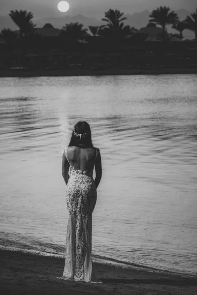 Girl in white dress on sunset sky, back view — Stock Photo, Image