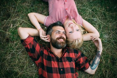 Aşık çift yeşil çimenlerin üzerinde rahatla. Aşık çift doğa yaz günü tadını çıkarın..