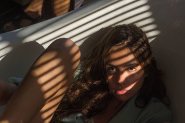 Işık ve gölge panjurlar genç sağlıklı cilt üzerinde gelen kadınla. Doğal makyaj kadınla banyoda sakin ol. Uzun esmer saçlı güzel kız. Güzellik moda bakmak modeliyle. Spa wellness ve sağlık