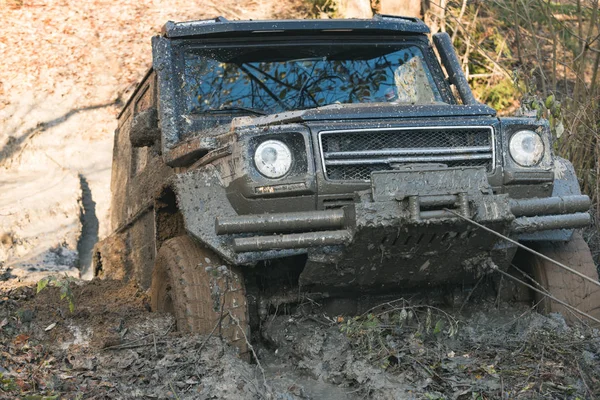 SUV est sorti de la flaque de boue par treuil de voiture . — Photo