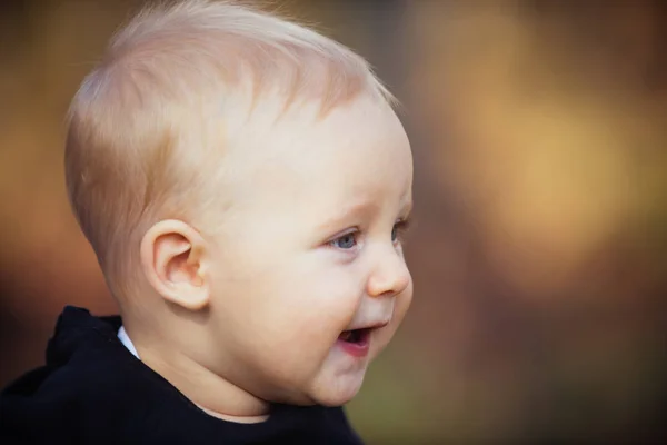 Baby jongen glimlach op vage aard. Kindje met blond haar buiten. Kid met schattig gezicht. Gelukkige jeugd onschuld en tederheid concept, kopie ruimte — Stockfoto