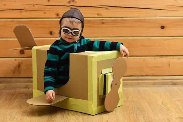 Niño pequeño jugar en avión de cartón, la infancia . — Foto de Stock