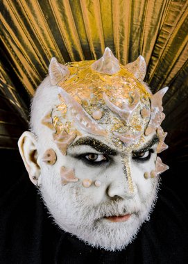 Dikenler veya siğiller, baş yüz pırıltılar ile kaplı, yakın çekim. Fantezi kavramı. Uzaylı, iblis büyücü makyaj. Sakallı canavar makyaj ile komuta sizde. Altın yaka, siyah arka plan ile iblis.