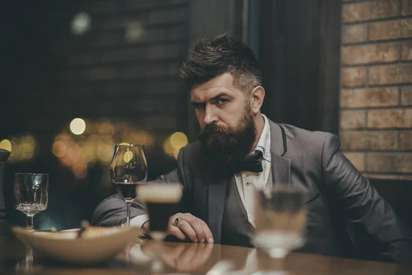 Porträt eines Geschäftsmannes mit einem Glas Champagner über dem Barhintergrund und Blick in die Kamera — Stockfoto