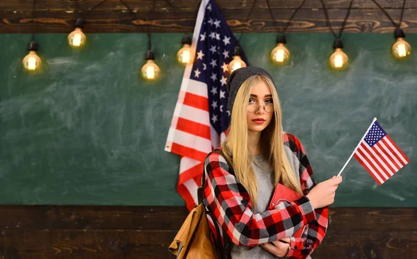 Estudiante busca el método de estudio que se adapte a su estilo de aprendizaje. Estudiante en gorra de graduación con certificado sobre bandera americana. tutor en línea siempre puede elegir de forma independiente . — Foto de Stock