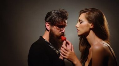 genç seksi birkaç kadınla güzel yüzü ve çıplak omuz esmer saçlı ve sakallı yakışıklı kırmızı çilek berry meyve yeme uzun sakallı