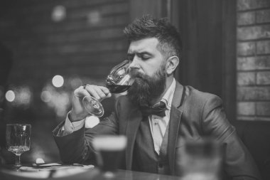 Kırmızı şarap, bir bardak şarap rengini adam değerlendirir. Sommelier 