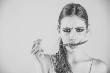 Kadın ağız pembe bir arka plan üzerinde kırmızı biber hold