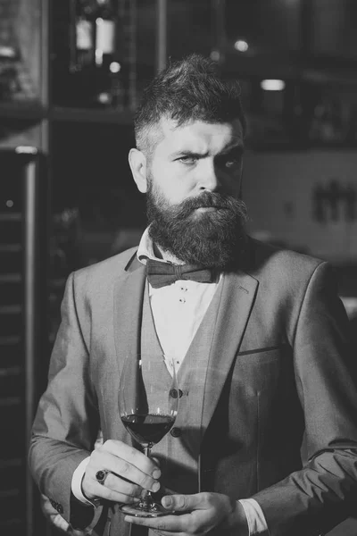 Confident winemaker in romantic atmosphere of cigar club. cigar club, serious winemaker with glass in business suit — Stock Photo, Image