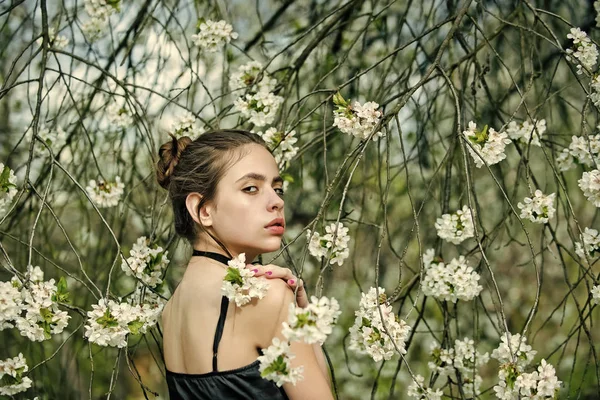Donna posa sugli alberi con fiori in fiore — Foto Stock