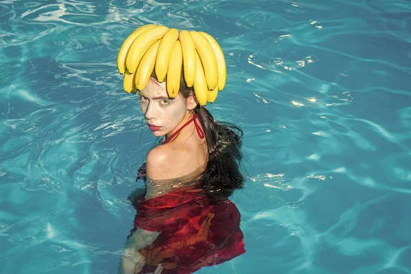 Mujer bonita relajarse en la piscina de lujo spa. bonita mujer con plátano en la cabeza —  Fotos de Stock