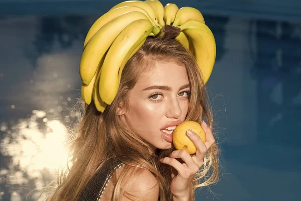 Mulher relaxar na piscina com limão. Vitamina em banana em menina perto de água. Dieta e comida orgânica saudável, vegetariana. Mulher sexy com frutas tropicais na piscina. Férias de verão e viagens ao oceano — Fotografia de Stock