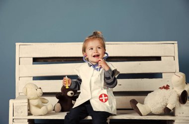 Evcil hayvan tahta bankta oturmak oyuncak ile mutlu bebek