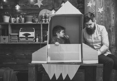 Baba, baba, küçük kozmonot ile çocuk oyun karton kutudan yapılan roket oturup. Roket fırlatma kavramı. Çocuk şirin çocuk oyun kozmonot, astronot. Çocuk mutlu oturmak karton el roket yapımı