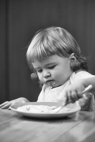 Küçük çocuk yulaf lapası yemek — Stok fotoğraf