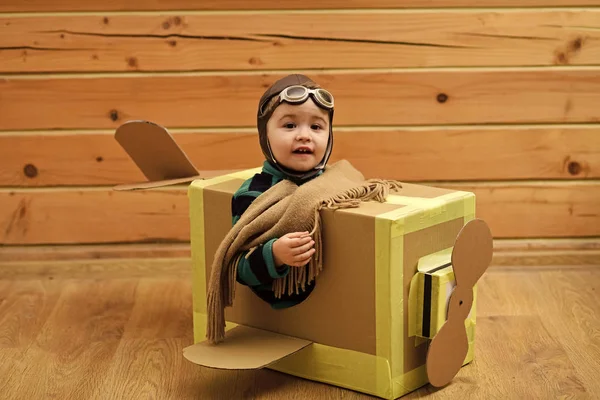 Хлопчик мрійник грає з картонним літаком — стокове фото