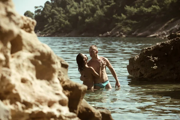 Jovem casal curtindo uns aos outros em uma praia — Fotografia de Stock