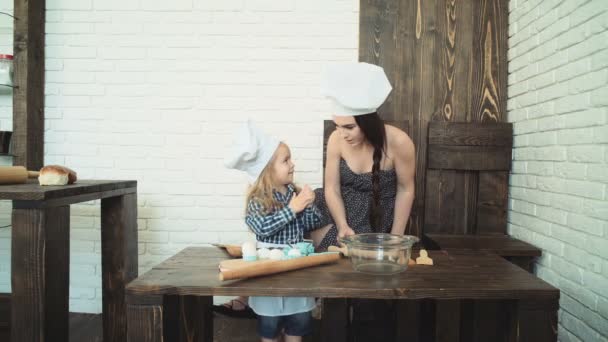 Feliz familia amorosa están preparando la panadería juntos. Madre e hija niña están cocinando galletas y divirtiéndose en la cocina. Comida casera y poco ayudante. — Vídeos de Stock