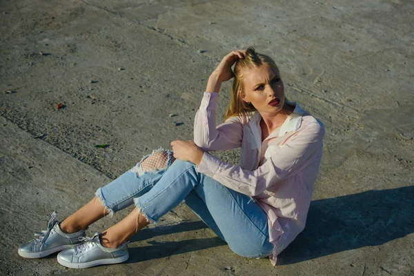 Vrouw zitten op cement grond, mode. — Stockfoto