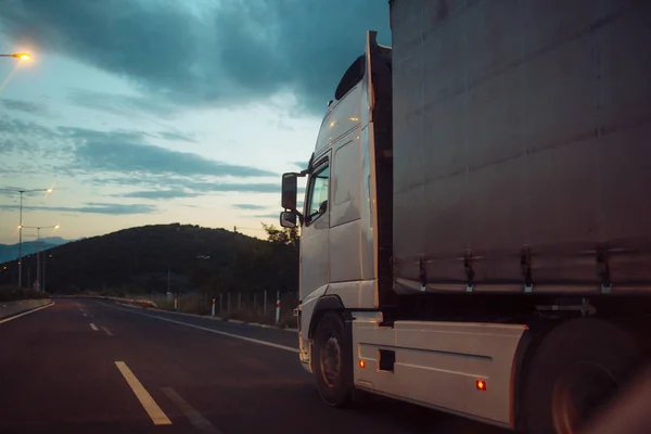 ?Argo busje, vrachtwagen, kamion transports goederen of items tussen landen. Internationaal transport concept. Camion, van ritten langs de weg in de avond, achterste weergave. — Stockfoto