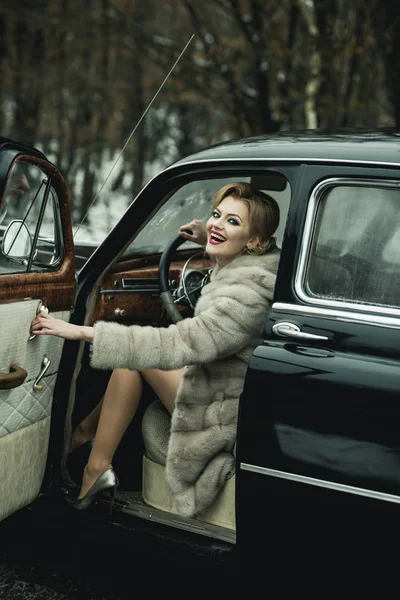 Uma acompanhante num carro antigo. menina chamada com cabelo elegante e maquiagem elegante . — Fotografia de Stock