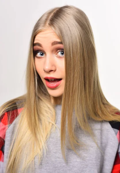Fröhliche junge Frau mit dicken Augenbrauen und langen blonden, glänzenden Haaren posiert im Studio isoliert auf weißem Hintergrund — Stockfoto