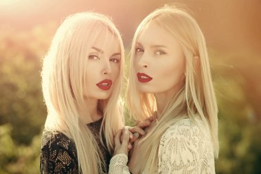 Kırmızı dudaklar ve uzun sarı saçları ile iki kadın