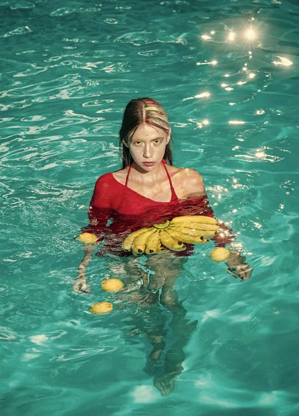 Woman relax in spa pool. Summer vacation and travel to ocean. Vitamin in banana at girl sitting near water. Dieting and healthy organic food, vegetarian. woman with tropical fruit in pool