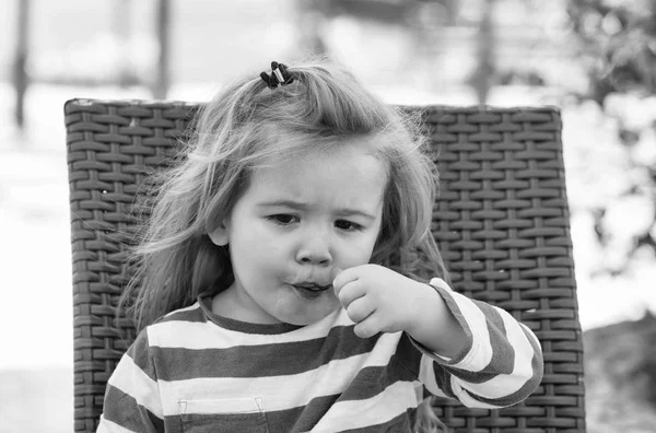 Ładny chłopczyk jeść smaczne lody w kawiarni na świeżym powietrzu — Zdjęcie stockowe