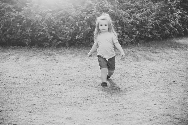 小男孩走在绿色的草地上 — 图库照片