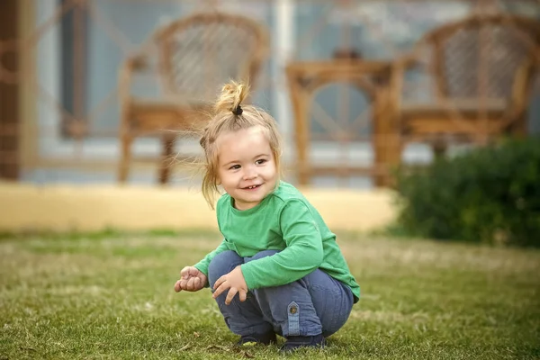 Klein kind zit op de weide gras — Stockfoto
