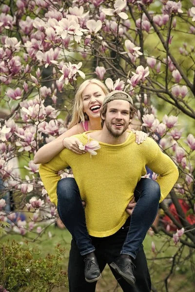 Sensual woman and man in magnolia bloom.