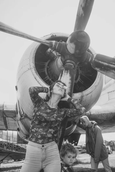 Família passar o tempo juntos, em excursão, avião no fundo, dia ensolarado. Conceito de lazer familiar. Mãe e pai e criança andando no museu da aviação ao ar livre. O pai parece cansado de andar. — Fotografia de Stock