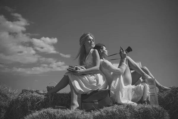 Девушки сидят на скамейке на голубом небе — стоковое фото