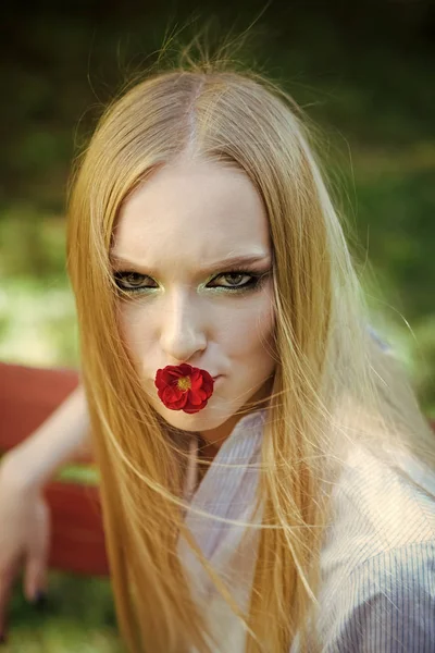 Bellezza donna con fiore rosso in bocca. Modello di bellezza con lunghi capelli biondi . — Foto Stock