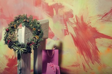 Noel köknar ağacı çelenk, ahşap sandalye üzerinde alışveriş çantası.