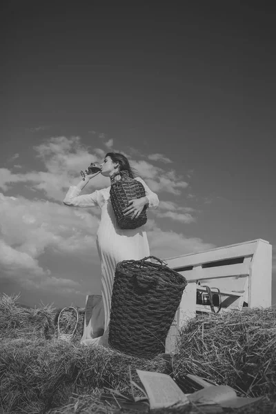 Женщина в белом платье пьет красное вино в солнечный день — стоковое фото