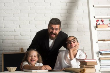 İlkokul çocukları ve Öğretmen sınıfta oturup.