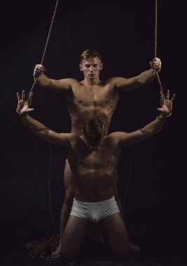 Güzel güzel genç ikiz erkek spor giyim spor egzersiz, studio siyah arka plan üzerinde atış yaparak uygun.