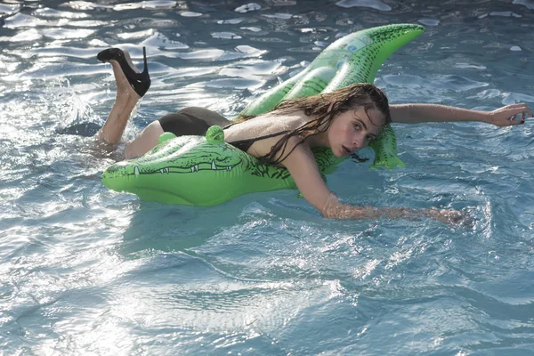 Portret van een mooie vrouw liggend op lucht matras in zwembad — Stockfoto