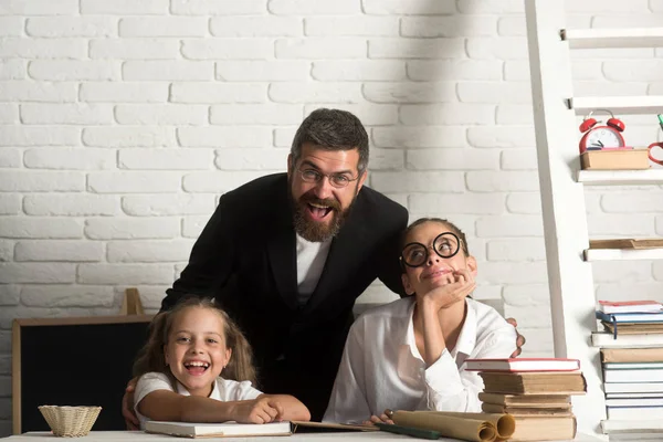 İlkokul çocukları ve Öğretmen sınıfta oturup.