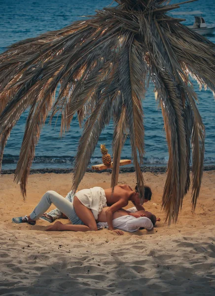 Joven pareja sexy en la playa con puesta de sol. Colores moda — Foto de Stock